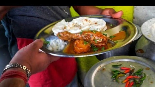 'Eating chicken leg piece with tandoori roti at Kolkata street food stall'